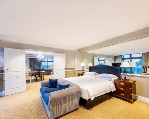 a bedroom with a bed and a couch and a chair at Hyatt Regency Harare The Meikles in Harare