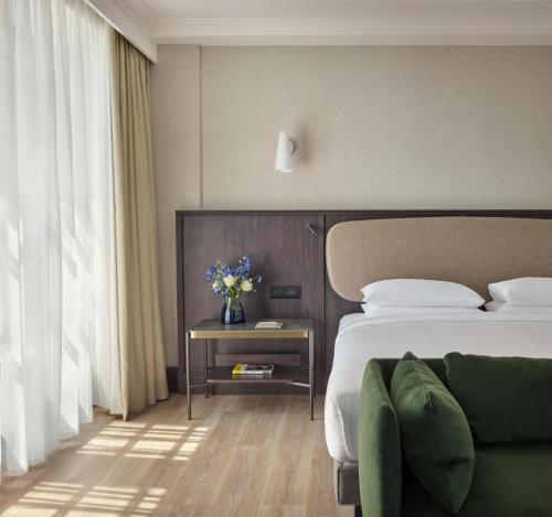 a hotel room with a bed and a table with flowers at Hyatt Regency London Blackfriars in London