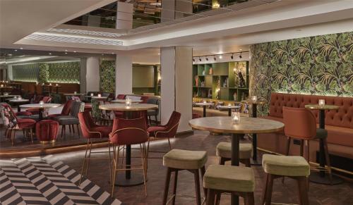 a restaurant with tables and chairs and a bar at Hyatt Regency London Blackfriars in London