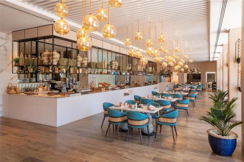 a dining room with tables and chairs and chandeliers at Hyatt Regency Harare The Meikles in Harare