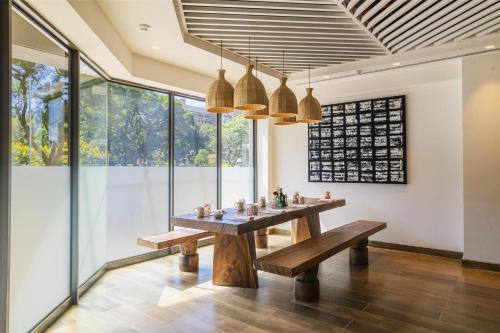 a dining room with a table and benches at Hyatt Regency Harare The Meikles in Harare