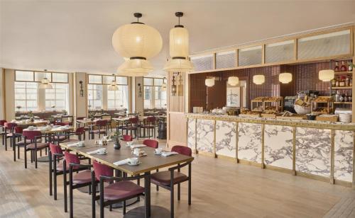 a restaurant with tables and chairs and a counter at Hyatt Regency London Blackfriars in London
