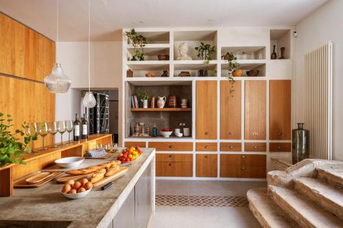 une cuisine avec des placards en bois et un comptoir avec de la nourriture. dans l'établissement Rieucoulon Estate, 18th century, 12 guests, à Montpellier