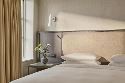 a bedroom with a bed with white pillows and a window at Hyatt Regency London Blackfriars in London