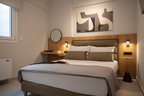 a bedroom with a large bed and a mirror at Pantheon Suites Moralis in Nafplio