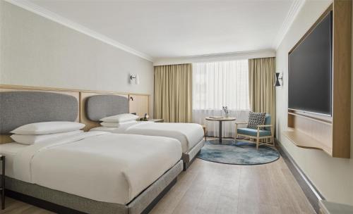 a hotel room with two beds and a television at Hyatt Regency London Blackfriars in London