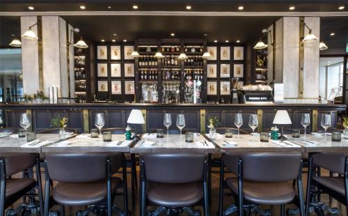a long table in a restaurant with chairs and wine glasses at Hyatt Regency London Blackfriars in London