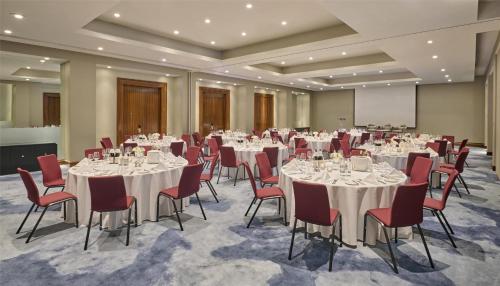 a conference room with white tables and red chairs at Hyatt Regency London Blackfriars in London
