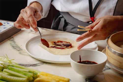 a person is eating food on a plate with a spoon at Hyatt Regency London Blackfriars in London