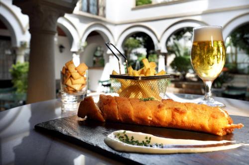 a table with a sandwich and a glass of wine at Eurostars Conquistador in Córdoba
