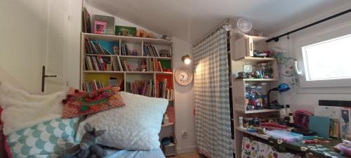 - une chambre pour enfants avec un lit et des étagères dans l'établissement Petite maison d'artitstes en Provence, à Auriol