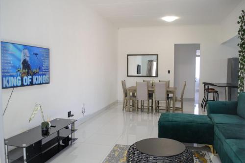 a living room with a green couch and a table at The View Apartment 5 in Lüderitz