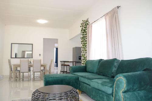 a living room with a green couch and a table at The View Apartment 5 in Lüderitz