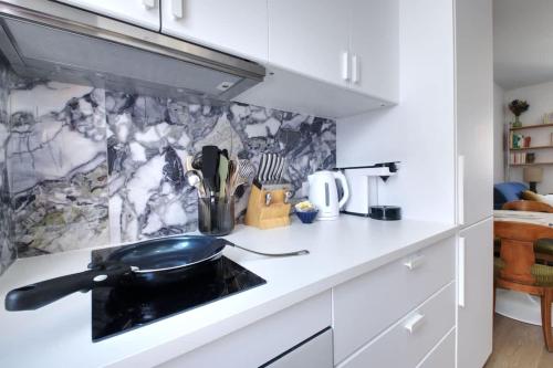 - un comptoir de cuisine avec poêle à frire dans l'établissement Échappée Belle-Joli T2-Centre de Dinard-Plage 500m, à Dinard