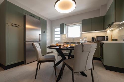 a kitchen with a table and chairs in a kitchen at Pantheon Suites Moralis in Nafplio