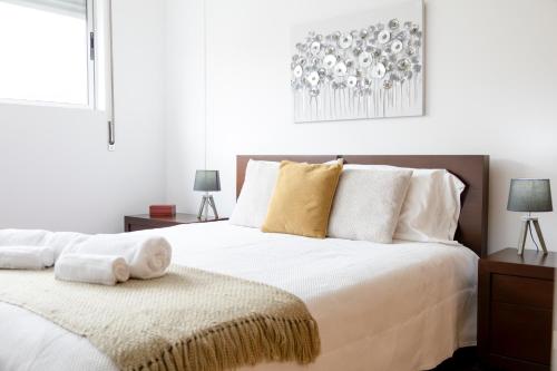 a bedroom with a large bed with white sheets and pillows at Paim Apartment in Ramalho
