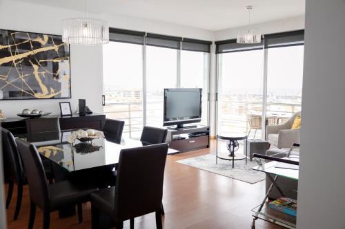 a living room with a dining table and a television at Paim Apartment in Ramalho