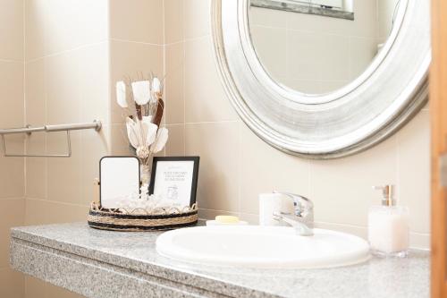 a bathroom with a sink and a mirror at Paim Apartment in Ramalho