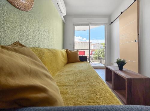 - un salon avec un canapé jaune et une fenêtre dans l'établissement T2 cosy avec terrasse & parking à 2 pas du port, à La Ciotat