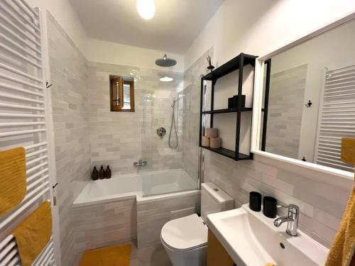 a bathroom with a tub and a toilet and a sink at Zöld Cica Vendégház in Hévíz