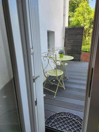 une porte menant à une terrasse avec une table et une chaise. dans l'établissement Tassigny - Charmant appartement/ terrasse - Port, à Vannes