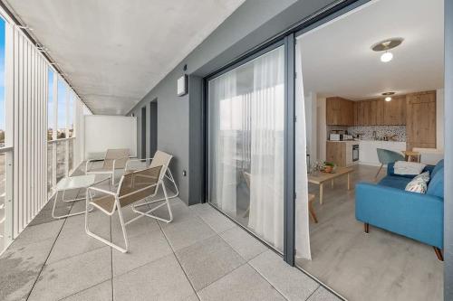 un salon avec un canapé bleu et une table dans l'établissement L'Odyssée - Bel appartement -Terrasse/Parking, à Vannes