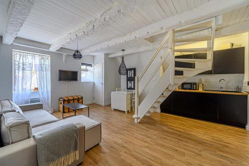 un salon avec un canapé et un escalier dans l'établissement Bohème, joli duplex, Intra-Muros/Port de plaisance, à Vannes