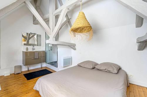 - une chambre blanche avec un lit et un lavabo dans l'établissement Bohème, joli duplex, Intra-Muros/Port de plaisance, à Vannes