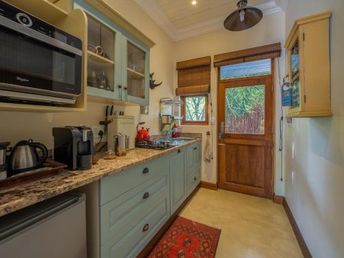 a kitchen with blue cabinets and a counter top at Kambaku River Lodge in Malelane