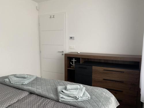 a bedroom with a bed and a wooden dresser at Balatonkenese Sunshine Villa in Balatonkenese