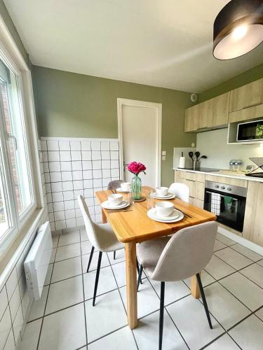 - une cuisine avec une table en bois et des chaises blanches dans l'établissement L épicentre Gare d Amiens, à Amiens