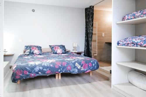 une chambre avec un lit avec un couvre-lit fleuri dans l'établissement souplex sur le port des sables pour 4 personnes, à Les Sables-dʼOlonne