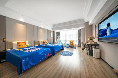 a bedroom with a blue bed and a flat screen tv at Atour Hotel Chengdu Taikoo Li Riverside in Chengdu