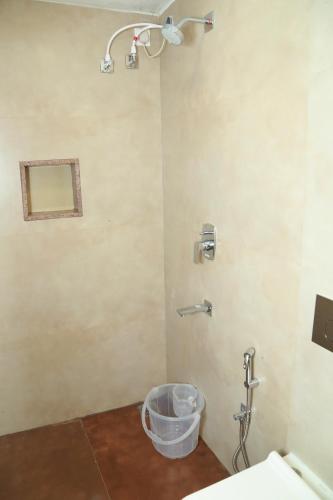 a bathroom with a shower with a bucket in it at The Berry House in Yercaud