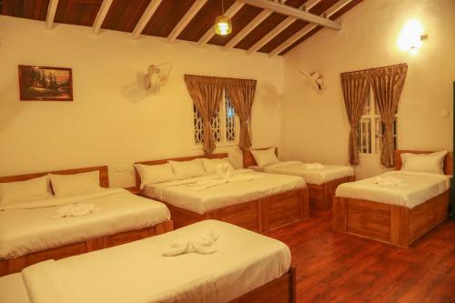 una habitación con tres camas en una habitación en The Berry House, en Yercaud