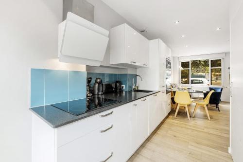 une cuisine avec des placards blancs et une salle à manger dans l'établissement L'ILOT - Jolie maison - Terrasse/300m plage-4 pers, à Saint-Malo