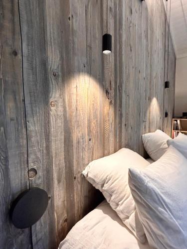 a bedroom with a wooden wall next to a bed at Chalet de Mielandre in Vesc