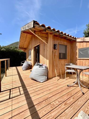 a wooden deck with a table and a house at Chalet de Mielandre in Vesc