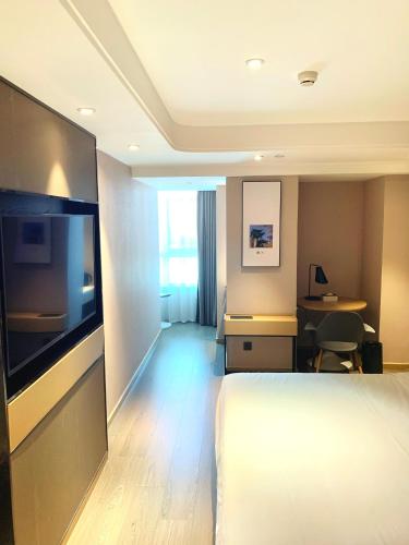 a hotel room with a bed and a flat screen tv at Atour Hotel Beijing Tongzhou Liyuan Subway Station in Tongzhou