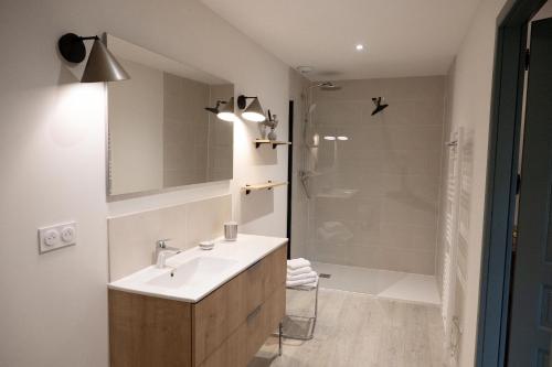 a bathroom with a white sink and a shower at La Métairie La Maison de Ninette in Castelculier