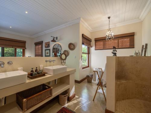 a bathroom with two sinks and a large mirror at Kambaku River Lodge in Malelane