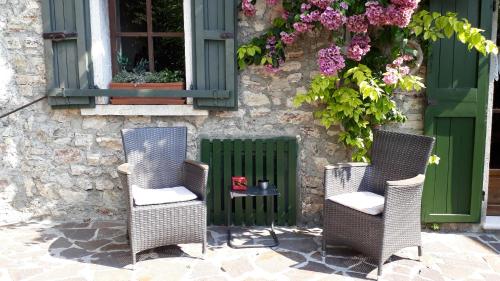 two chairs and a table in front of a building at Casa Muslone in Muslone