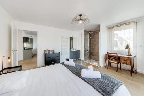 une chambre blanche avec un grand lit et un bureau dans l'établissement Rivage - Beau 2 chambres - Parking/Plage 300m, à Dinard