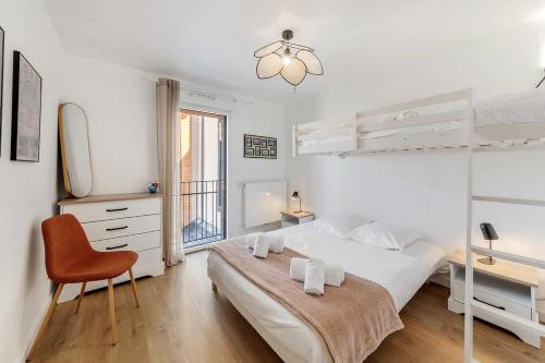 - une chambre blanche avec un lit, un bureau et une chaise dans l'établissement Rivage - Beau 2 chambres - Parking/Plage 300m, à Dinard
