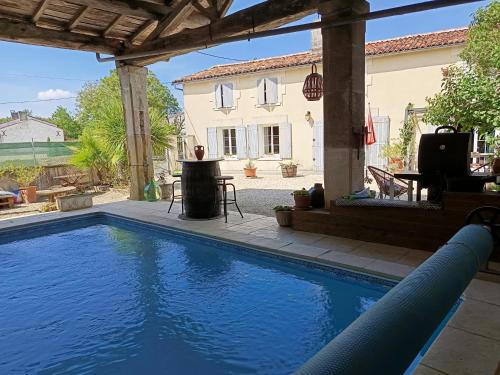a swimming pool in front of a house at La charentaise ch d'hôtes ,Studio in Chérac
