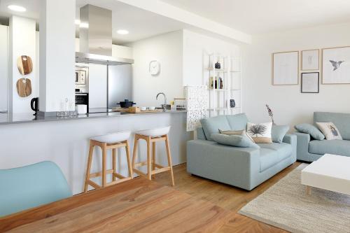 a living room with a couch and a kitchen at H SUITE3B by Smiling Rentals in Hondarribia