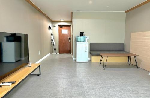 a room with a couch and a table and a refrigerator at Sokcho Good Morning Hotel and Resort in Sokcho