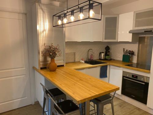 une cuisine avec une table en bois et un vase de fleurs dans l'établissement Le Sainte Claire - City Center, à Annecy