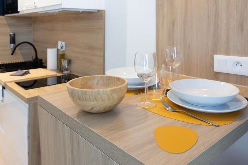 - une cuisine avec une table, des bols et des verres à vin dans l'établissement Suite - Strasbourg Gare - Petite France - Commerces à Proximité, à Strasbourg