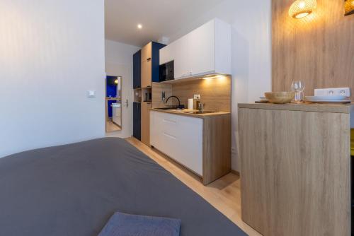 une cuisine avec un lit et un comptoir avec un évier dans l'établissement Suite - Strasbourg Gare - Petite France - Commerces à Proximité, à Strasbourg